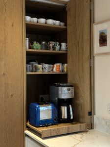 Bespoke bi-fold coffee station with oak cabinetry, integrated storage and quartz worktops