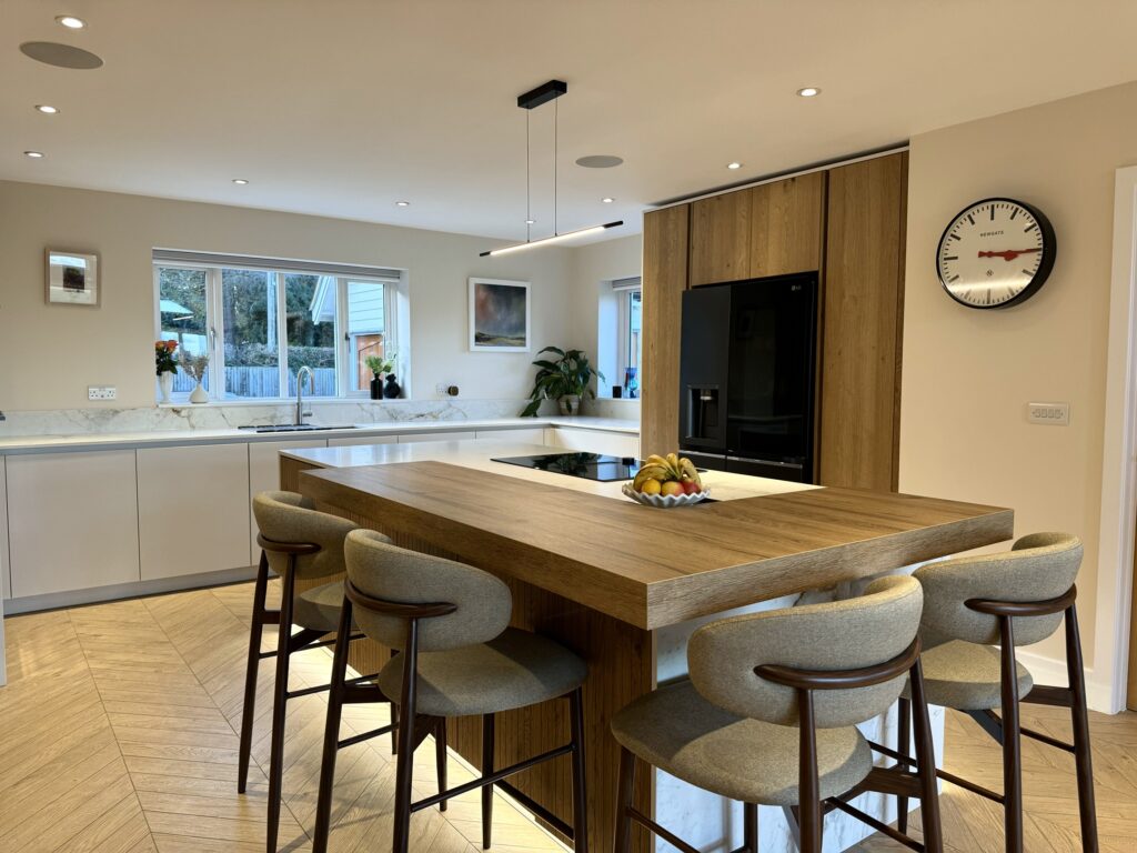 Kitchen island design featuring fluted oak cabinetry, quartz worktops and integrated seating
