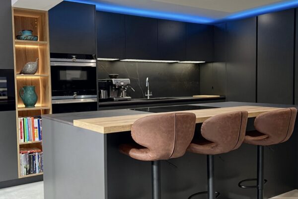 handleless kitchen with dark graphite cabinetry, oak island and integrated appliances